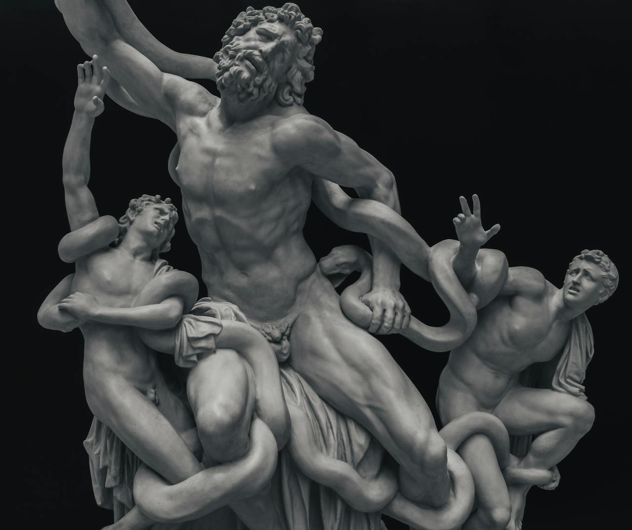 Detailed view of the ancient marble sculpture 'Laocoon and His Sons' on a dark background.