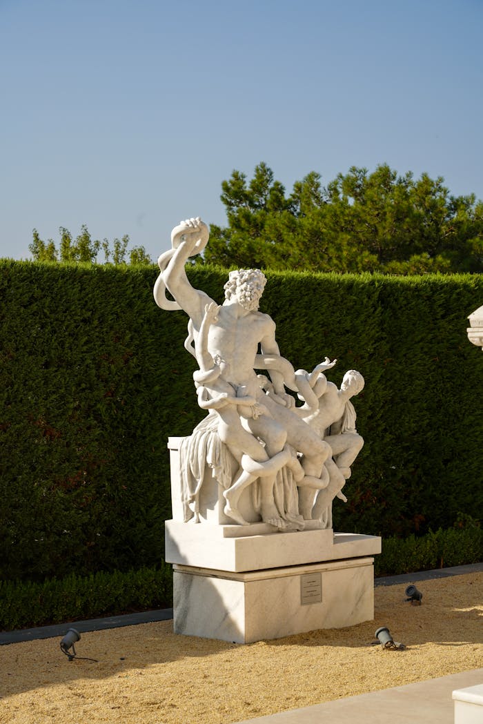 A detailed stone sculpture captured outdoors in a bright garden, showcasing classical art.